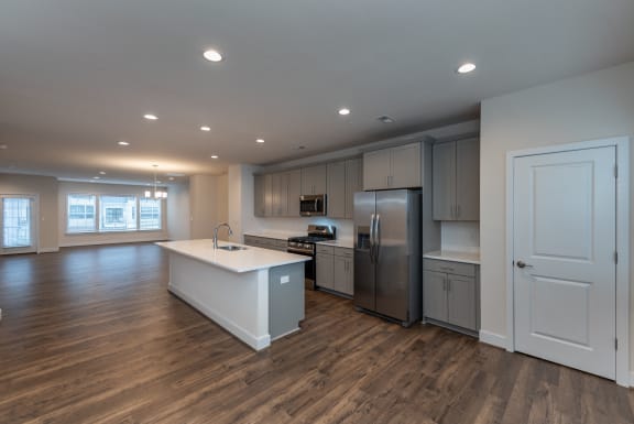 an open kitchen with an island and stainless steel refrigerator
