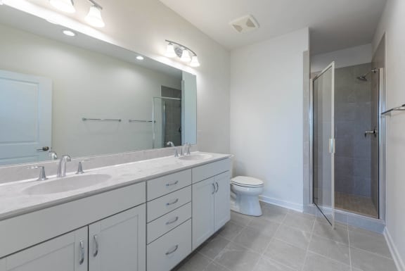 a bathroom with a large mirror and a toilet and a shower