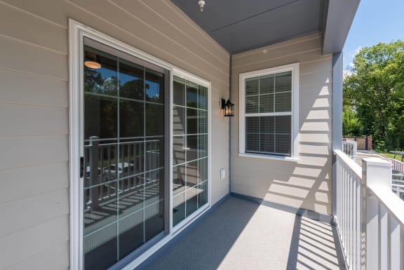 a covered porch with sliding glass doors and a staircase
