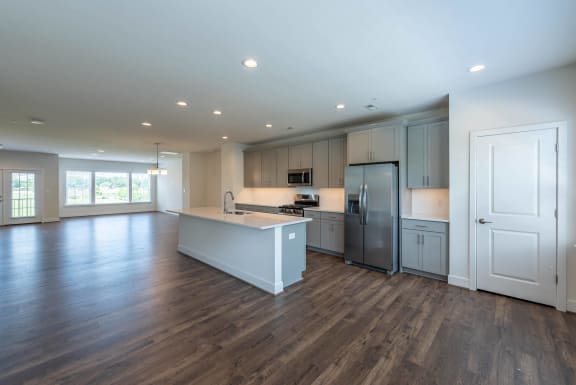 a large kitchen with white cabinets and stainless steel appliances