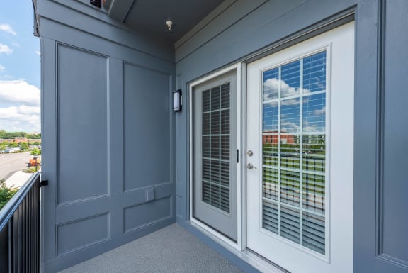 a window with white shutters on a blue house