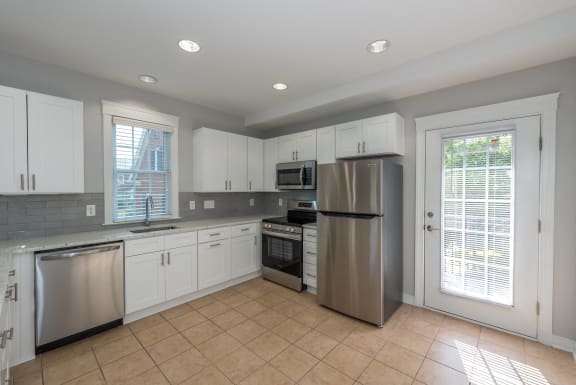 a kitchen with white cabinets and stainless steel appliances