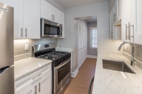 a kitchen with stainless steel appliances and white cabinets