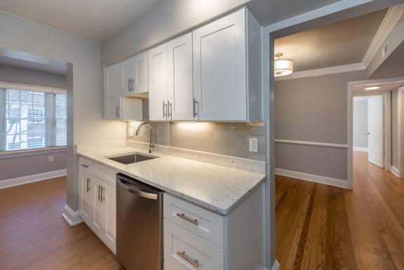 an empty kitchen with white cabinets and a sink