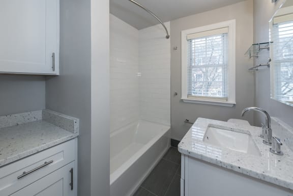 an empty bathroom with a sink and a tub and a window