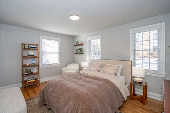 A bedroom with a bed, nightstand, and window.