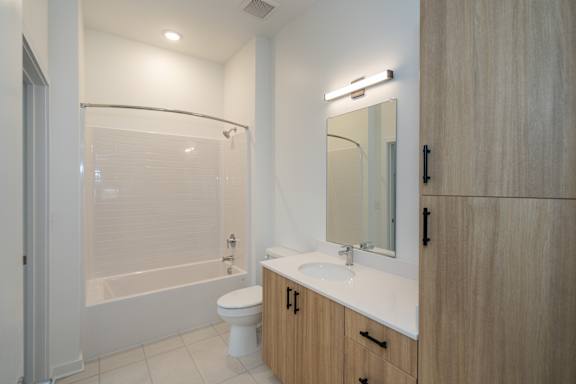 A3 Bathroom with Tile Flooring, Wood Tone Cabinetry with Linen Cabinet