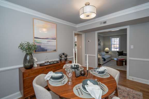 A dining room with a wooden table set for a meal.