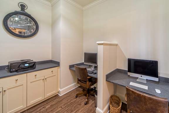 A room with a desk, chair, and a clock on the wall.