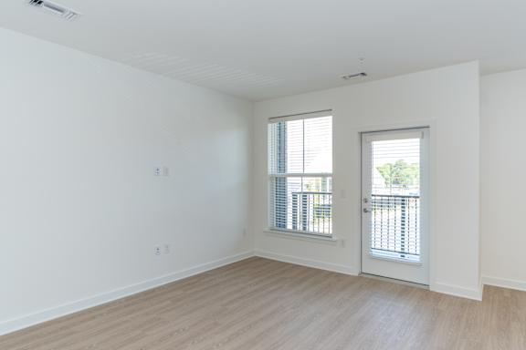 A room with a door and a window with blinds.