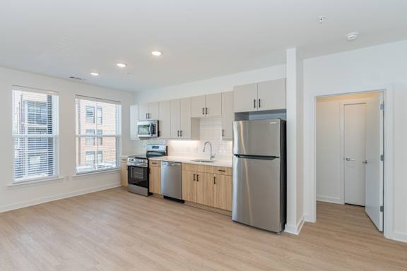 A modern kitchen with stainless steel appliances and wooden cabinets.