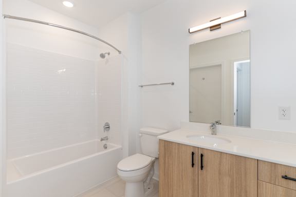 A white bathroom with a toilet, sink, and bathtub.