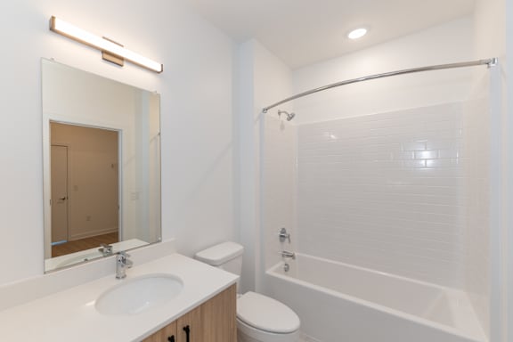 A white bathroom with a sink, toilet, and bathtub.