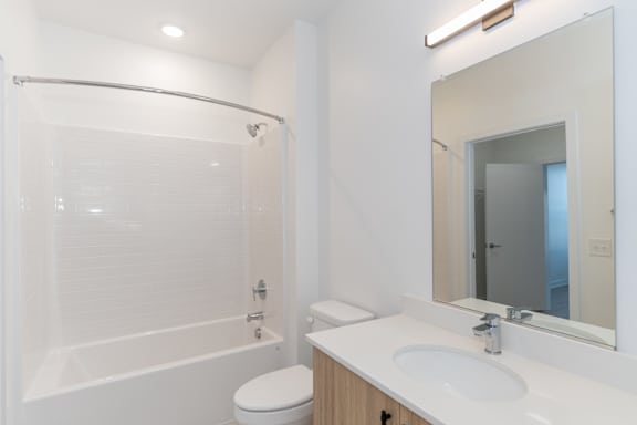 A white bathroom with a toilet, sink, and shower.
