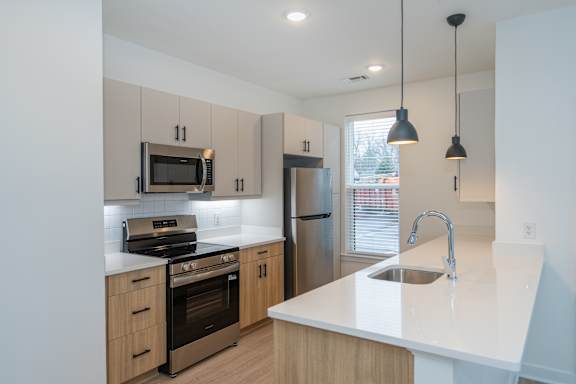 Bright kitchen with a large peninsula countertop and pendant lighting