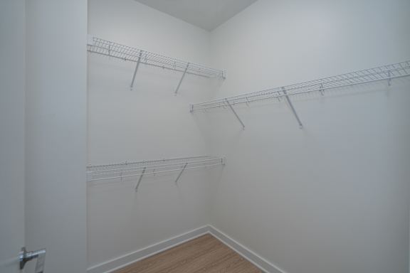 Primary bedroom walk in closet with wire rack shelving