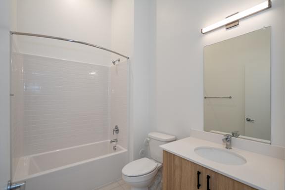 Bright second bathroom with bathtub and tile flooring