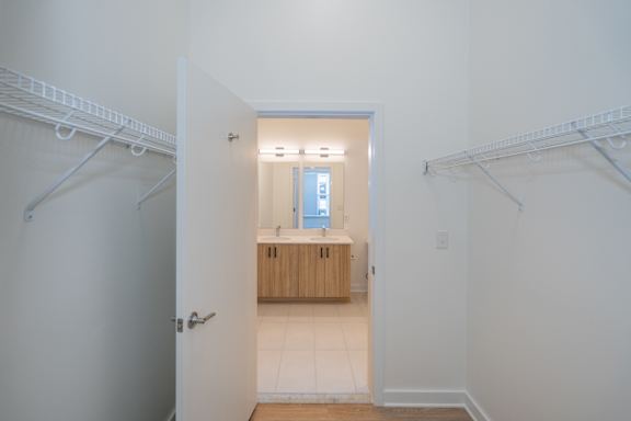 Walk through closet with shelving on both sides, connects bedroom to bathroom