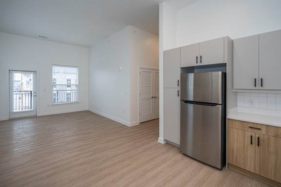 Open kitchen with stainless steel appliances, LVP flooring and two tone cabinetry