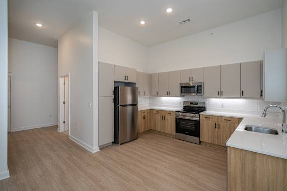 Open kitchen with LVP floors and stainless steel appliances.
