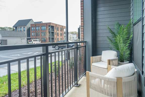 A balcony with a chair and a potted plant.