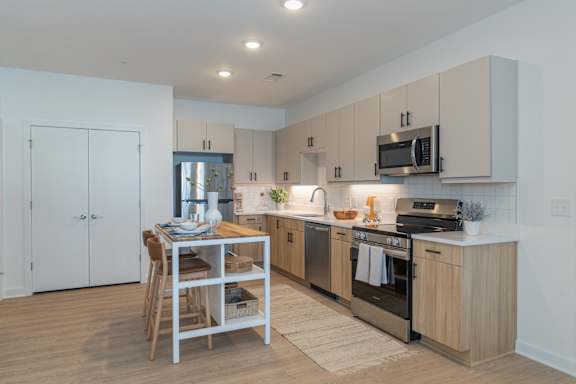 A kitchen with a table and chairs in the middle of it.