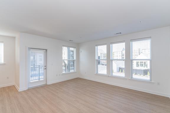 A large empty room with wooden floors and white walls.