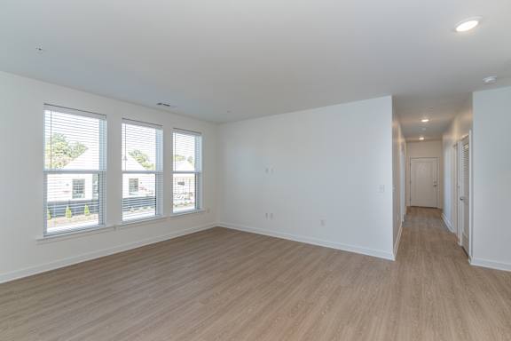 A large empty room with wooden floors and white walls.