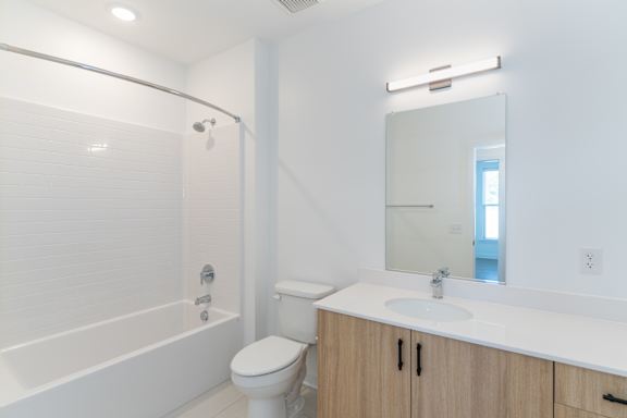A white bathroom with a toilet, sink, and bathtub.