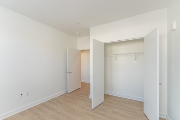 A room with a white wall and a wooden floor.