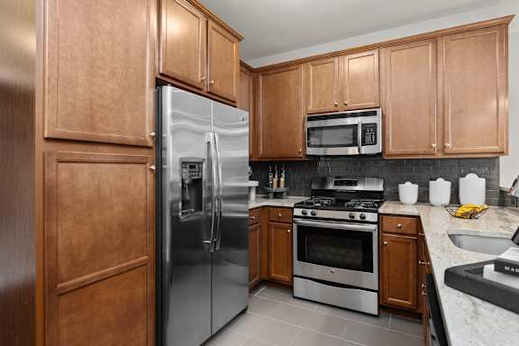 A kitchen with a refrigerator, oven, microwave, and sink. at Merion at Cross Keys Apartments, Williamstown