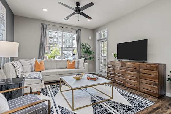 A living room with a grey couch, a coffee table, and a flat screen TV.