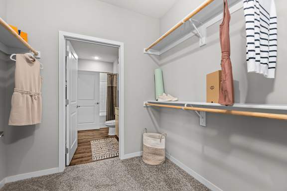 A small, clean, and organized bedroom with a closet and a mirror.