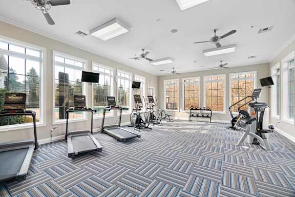 A spacious gym with treadmills, exercise bikes, and other equipment.