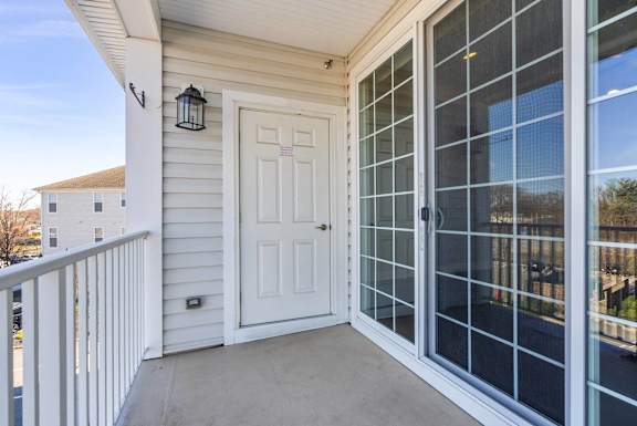 A white door with a glass window is on the side of a house.