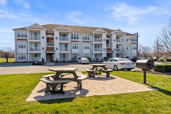 A large apartment building with a picnic table in front of it.