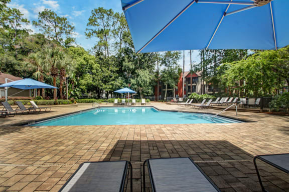 a swimming pool with chairs and umbrellas at the resort at Timberwalk at Mandarin Apartment Homes, Florida, 32257