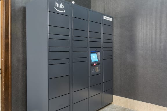 a large group of lockers in a building with a digital screen at The Collings at the Lumberyard, Collingswood, NJ