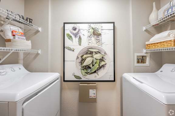 A bathroom with a white toilet and a framed picture of a bowl of fruit.