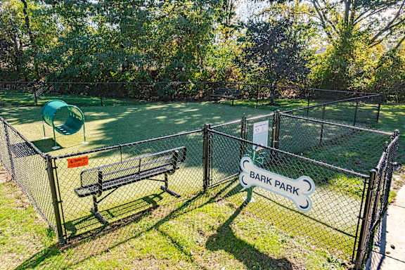 A tennis court with a sign that says Bark Park.