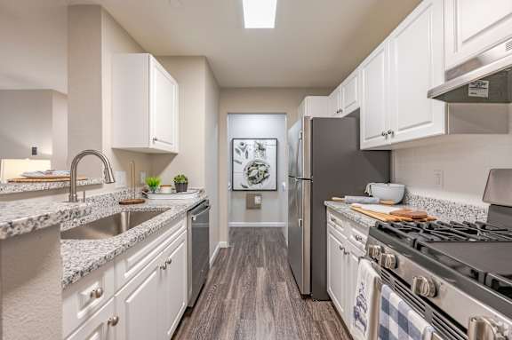 A kitchen with a stove top oven and a refrigerator.