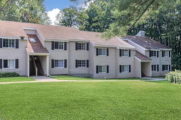 A large house with a green lawn in front.