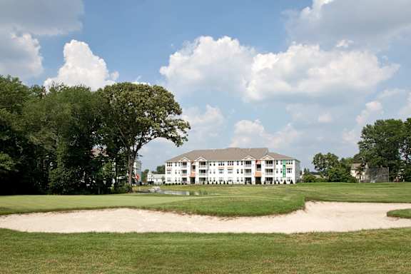 A white building with a green lawn in front of it.