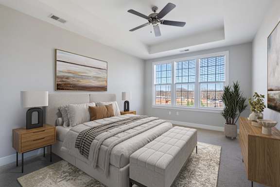 A bedroom with a large bed, a ceiling fan, and a painting on the wall.