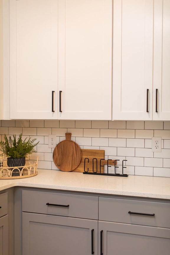 a white kitchen with white cabinets and a counter top and a sign that says coffee at The Yards at Malvern, Malvern, PA