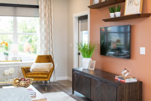a living room with a tv and a chair and a table at The Yards at Malvern, Malvern, PA