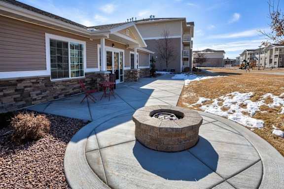 A fire pit sits in the middle of a concrete patio.