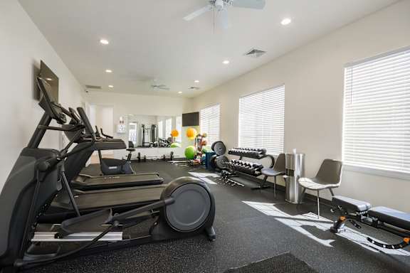 A spacious home gym with a variety of exercise equipment.