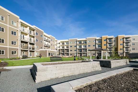 Apartment complex with a large grassy area in front.