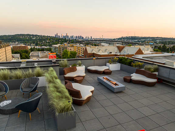 A rooftop patio with a fire pit and seating area.